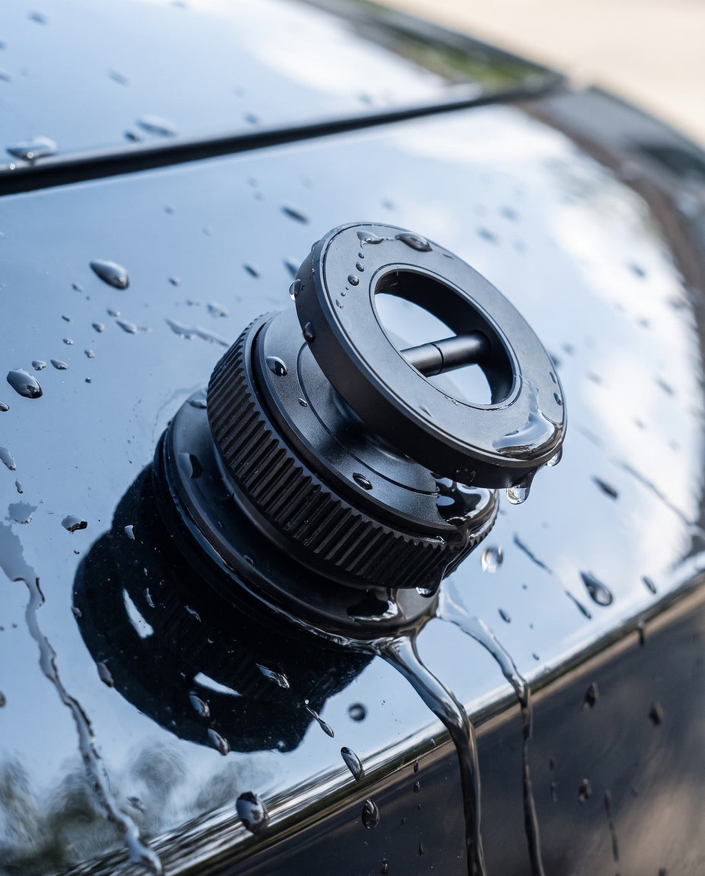 Suction-locked to wet car exterior, water pouring